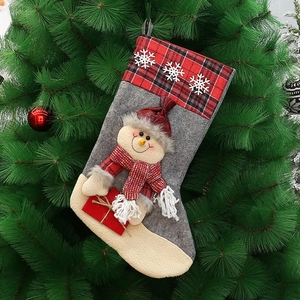 Detail of grey felt Christmas stocking with 3D snowman and red plaid cuff on tree