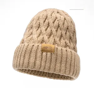 Close-up of khaki winter knit beanie featuring thick texture and branded leather patch