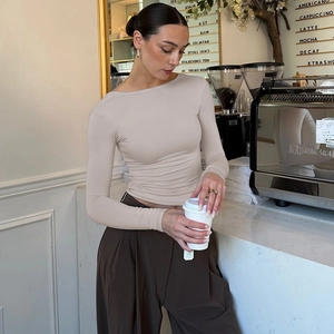 Top beige chic con schiena scoperta a maniche lunghe e pantaloni marroni a gamba larga