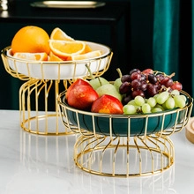 Detail of high and low ceramic egg holders with elegant golden birdcage metal wire stands