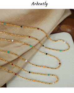 Macro shot of colorful enamel beads on a 18k gold plated stainless steel curb chain
