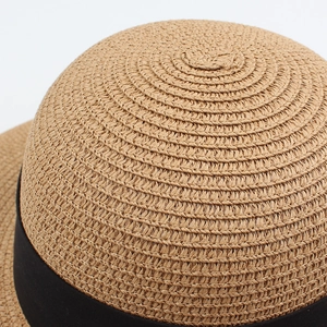 Macro shot of high-density straw weave texture and black decorative ribbon on sun hat