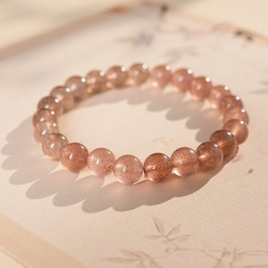 Macro detail of translucent pink strawberry quartz beads showing natural mineral inclusions