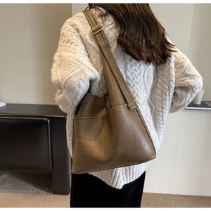 Braune PU-Leder Tragetasche mit breiten Trägern, Rückansicht am Modell in minimalistischem Raum