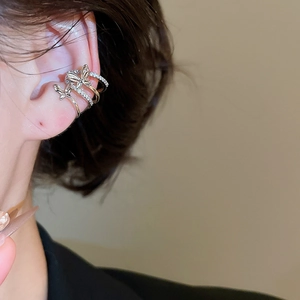 Detail of silver multi-layer butterfly ear cuff with sparkling zircon on a model's ear