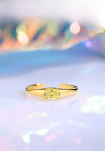 Macro shot of gold S925 silver open ring featuring a central oval yellow gemstone