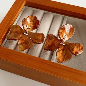 Vintage amber resin butterfly earrings with subtle rhinestone accents on a velvet box