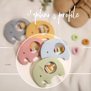 Detail of wooden elephant baby rattles with colorful rings and smooth timber finish