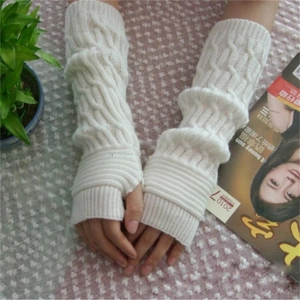 Detailed close-up of white cable-knit fingerless arm warmers with ribbed elastic cuffs