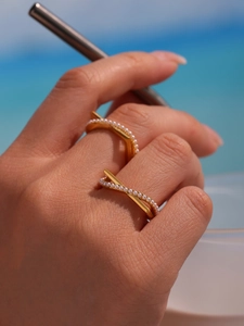 Detailed view of elegant gold-plated rings with micro pearls on a woman's hand