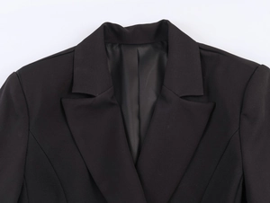 Detailed view of notch lapels and shoulder structure on a black double-breasted blazer