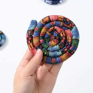 Close-up of a colorful handmade woven bendable hair tie with ethnic fabric patterns