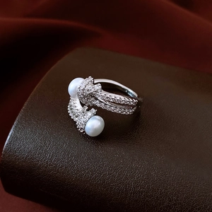 Macro view of bypass ring with white pearls and pavé cubic zirconia on textured leather