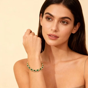 Elegant gold emerald bracelet with oval green stones and micro-pave cubic zirconia crystals