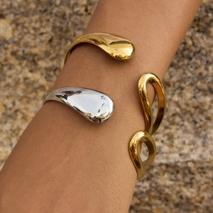Minimalist 18K gold and silver plated stainless steel open bangles on a model's wrist