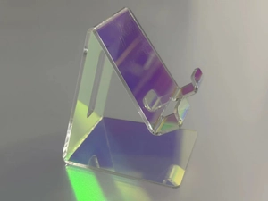 Macro detail of acrylic phone stand showing iridescent holographic surface under studio light
