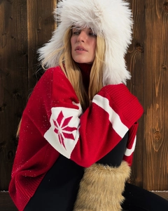 Close-up of red winter knit sweater with white stripes and snowflake patterns detail
