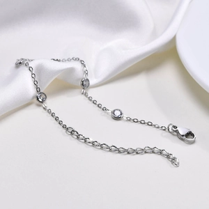 Macro view of silver stainless steel chain bracelet with four bezel-set round crystals