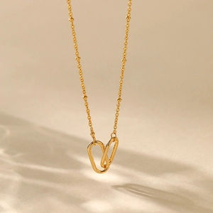 Detail of 18K gold plated interlocking oval pendant with elegant fine bead chain necklace