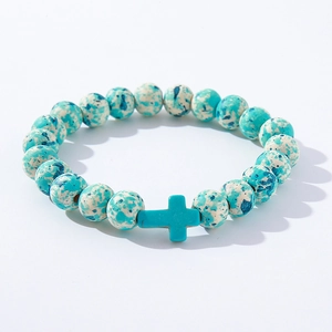 Detail of blue turquoise cross bead and speckled round stones on the beaded bracelet
