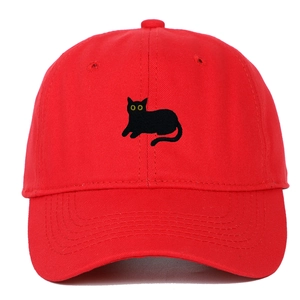 Close-up of a red baseball cap with a detailed black cat embroidery on a white background