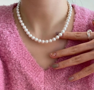 Close-up of model wearing 925 sterling silver necklace with round white lustrous pearls