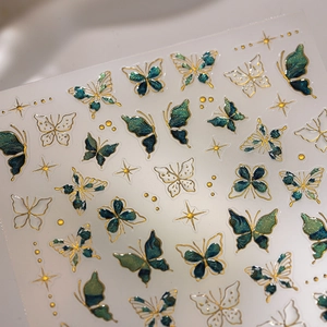 Golden butterfly nail stickers with emerald green pearlescent finish and star accents
