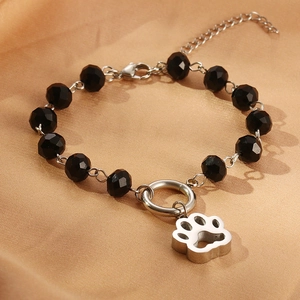Close-up of black faceted beads and hollow paw pendant on a silver-tone bracelet
