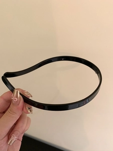 Close-up of minimalist black acrylic headband with interior anti-slip teeth detail