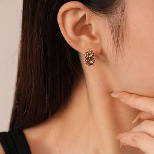 Close-up of elegant amber crystal geometric earrings worn on a female model