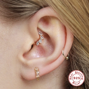 Macro-opname van gouden 925 zilveren oorpiercings met marquise en rechthoekige edelstenen