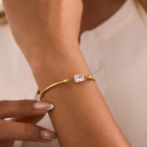 Detail of 18K gold-plated bangle featuring a rectangular zircon and polished beads