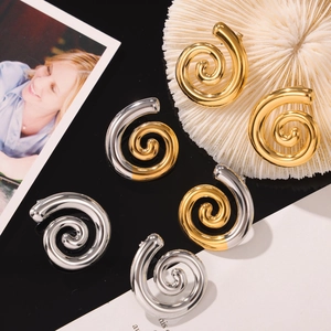 Boucles d'oreilles spirales géométriques en or et argent polis sur un fond de style moderne
