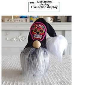 Detail of Halloween gnome featuring a black pointed hat with sugar skull embroidery