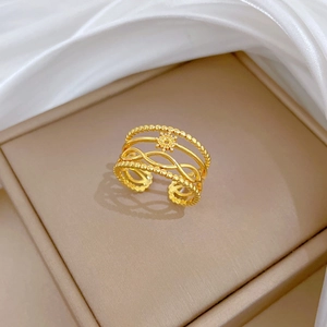 Détail d'une bague multicouche dorée avec motif soleil posée sur un coffret bijoux