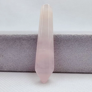 Close-up of polished natural rose quartz hexagonal point crystal tower on grey velvet