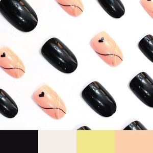 Glossy black and nude pink press-on nails with heart patterns and rose gold line art