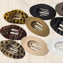 Flat lay collection of nine leopard print and matte hair claws in various colors