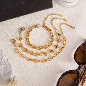 Detailed set of three golden stainless steel chain necklaces with lobster clasps