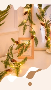 Détail de guirlande de Noël avec aiguilles de pin vertes, cônes et lumières LED chaudes
