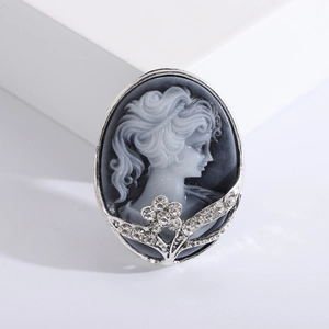 Retro queen relief brooch in silver alloy with rhinestone floral accents on white background