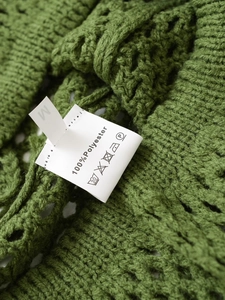 Detailed view of garment care label for M size green knitwear made of 100% polyester