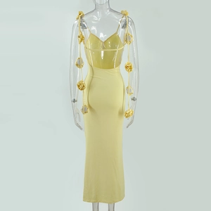 Détail d'une robe maxi dos nu jaune clair avec bretelles à fleurs 3D en cascade