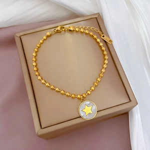 Dettaglio del bracciale a sfere in acciaio dorato con ciondolo stella in madreperla