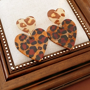 Macro view of double heart earrings with vintage leopard print and resin finish