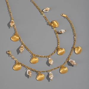 Détail de breloques coquillage et conque en acier doré 18 carats sur les bijoux