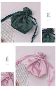 Detailed shot of dark green and lavender satin drawstring storage bags with ribbon ties