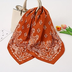 Seidenschal mit Paisleymuster in Karamell an Handtasche, elegantes Satin-Halstuch