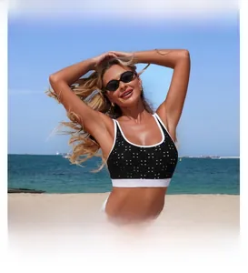 Detail of black polka dot bikini top with white elastic bands on a sunny beach