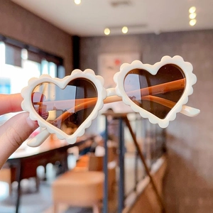 Cute cream-colored heart shaped sunglasses for children with scalloped wavy frame edges